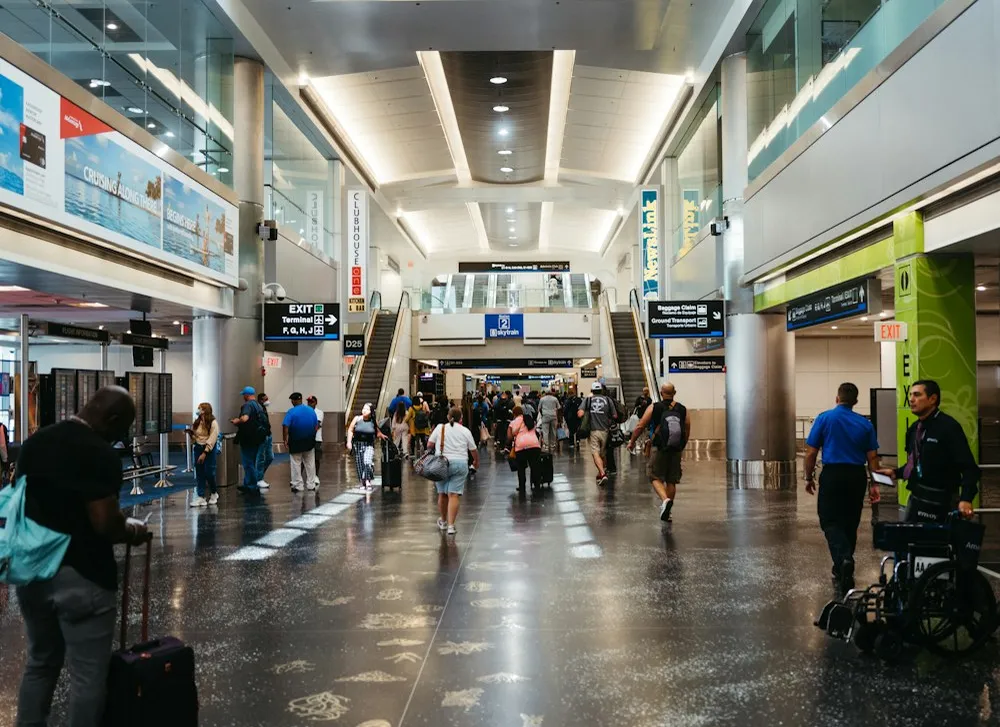 Travelers walking through a bright airport terminal