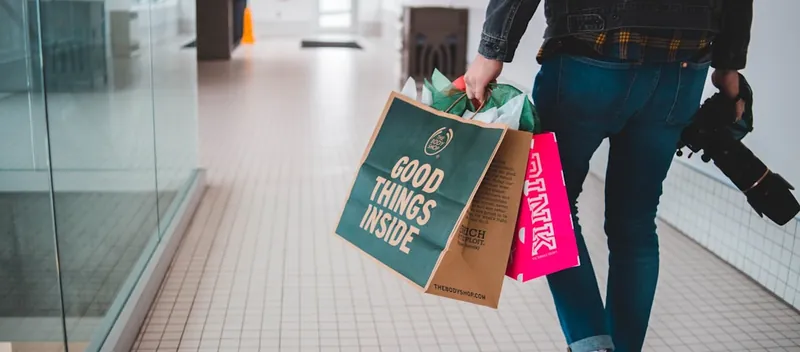 A shopper carrying paper bags